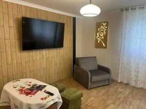 a living room with a chair and a television on a wall at Pokoje u Pawloka - BLISKO TERMY CHOCHOŁOWSKIE in Ciche