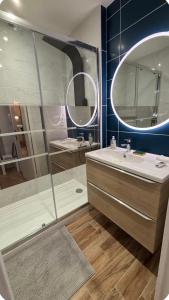 a bathroom with a shower and a sink and a mirror at Bénodet appartement 100m de la plage thalasso 2chambres parking privé internet avec box in Bénodet