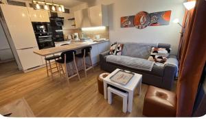 a living room with a couch and a kitchen at Bénodet appartement 100m de la plage thalasso 2chambres parking privé internet avec box in Bénodet