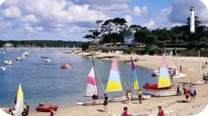 people on a beach with sailboats in the water at Bénodet appartement 100m de la plage thalasso 2chambres parking privé internet avec box in Bénodet