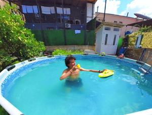a man in a swimming pool with a toy at Friends glamping & Sauna in Kutaisi