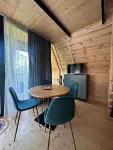a room with a table and chairs and a kitchen at Cottage Green Horizon Buknari in Buknari