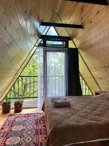 a large bed in a room with a large window at Cottage Green Horizon Buknari in Buknari