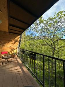 a balcony of a house with a table and a tree at Cottage Green Horizon Buknari in Buknari