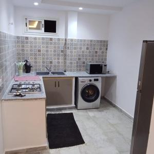 a kitchen with a washer and a stove and a dishwasher at Résidence Rahma in Hammam Chott