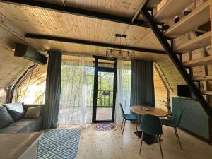 a living room with a table and a couch at Cottage Green Horizon Buknari in Buknari