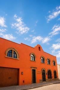 an orange building with windows and a blue sky at Hotel San Jose Centro Historico in San Luis Potosí +15 photos