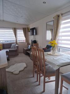 a living room with a table and chairs and a couch at Ascot at Lochlands in Forfar +3 photos