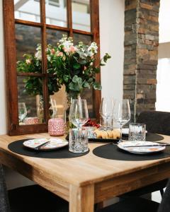 a wooden table with plates and glasses and a vase with flowers at Feels like home just 10 mins from the centre in Tallinn