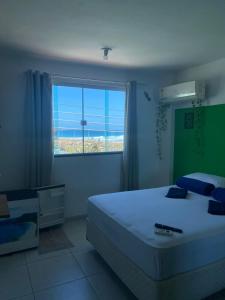 a bedroom with a bed and a large window at Suites Quebra Mar in Rio de Janeiro