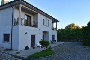 a white building with a balcony and a courtyard at Casa da Aldeia in Penafiel