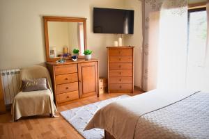 a bedroom with a bed and a dresser with a mirror at Casa da Aldeia in Penafiel +33 photos
