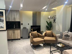 a living room with two chairs and a couch at HSQ Towers in Murree