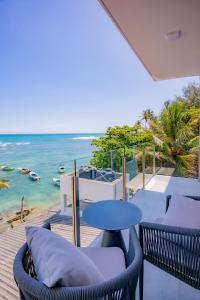 a balcony with chairs and a table and the ocean at Iconic Polhena in Matara