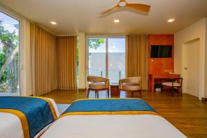 a bedroom with two beds and a desk and a window at Iconic Polhena in Matara