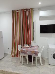 a dining room with a table and chairs and a curtain at Résidence Rahma in Hammam Chott