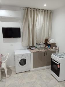 a kitchen with a washing machine and a sink at Résidence Rahma in Hammam Chott