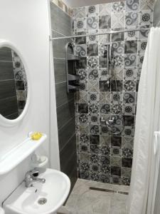 a bathroom with a sink and a shower at Résidence Rahma in Hammam Chott
