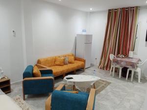 a living room with a couch and a table at Résidence Rahma in Hammam Chott