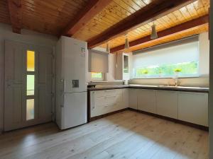 a kitchen with a white refrigerator and a window at Dodo Land in Săcel