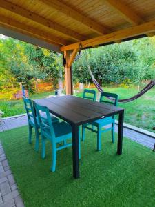 a black table and chairs under a wooden roof at Dodo Land in Săcel +3 photos