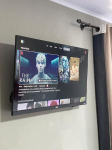 a flat screen tv hanging on a wall at suíte perto da praia in Imbituba