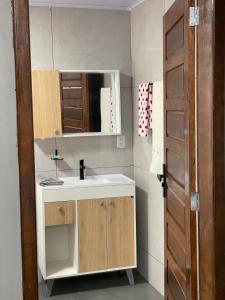 a bathroom with a sink and a mirror at suíte perto da praia in Imbituba +12 photos