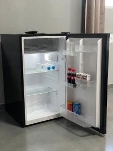 an empty refrigerator with its door open in a room at suíte perto da praia in Imbituba