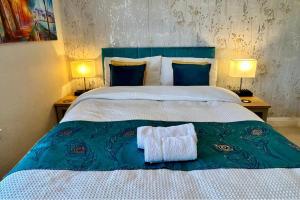 a bedroom with a large bed with two lamps and a towel at Character Bedford Apartment with Two Bedrooms in Bedford