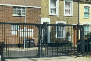 a black gate in front of a brick building at Character Bedford Apartment with Two Bedrooms in Bedford