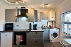 a kitchen with white cabinets and a washer and dryer at Character Bedford Apartment with Two Bedrooms in Bedford