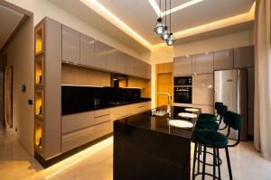 a kitchen with a black island and green bar stools at Luxurious Marrakech Villa Pool, Hammam,Cinema in Marrakesh