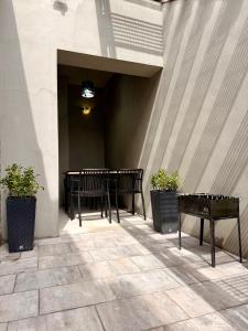 a patio with a table and two benches and plants at Федорцьо in Mukacheve