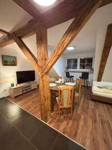 a living room with wooden beams and a table and a couch at Penzion Mlýnický Dvůr in Červená Voda