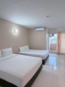 a hotel room with two beds and a window at Smile Bed Hotel in Sathani Khlong Rian +24 photos