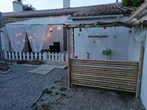 a white house with a white fence and a gate at La BK'ne studio 2 à 4 personnes in Villeneuve-en-Retz