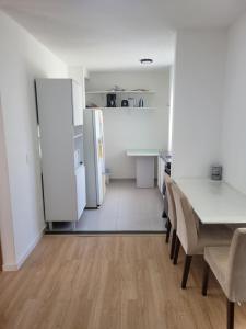 a kitchen and dining room with a table and a refrigerator at Lugar tranquilo in Biguaçu
