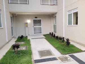 a walkway in front of a building with a door at Lugar tranquilo in Biguaçu