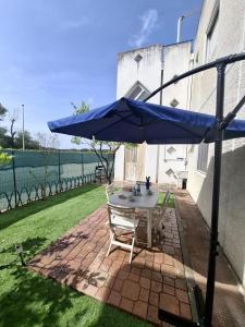 a table and chairs under an umbrella on a patio at La casa del delfino in Policoro
