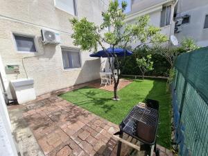 a small garden with a table and an umbrella at La casa del delfino in Policoro +8 photos
