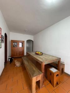 a room with a wooden table and a bench at Quarto da Fran - perto da UFF in Niterói