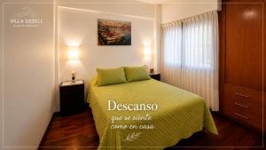 a bedroom with a bed with a green blanket at Reflejo de Mar in Villa Gesell