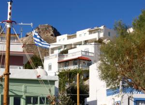 a flag flying in front of a white building at Asterias in Panteli