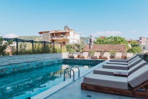 a swimming pool with chaise lounges next to a building at Hotel ENAD in Ksamil