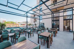 a restaurant with tables and chairs and a pool at Hotel ENAD in Ksamil