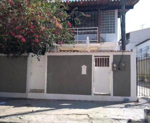 a house with a gate and a garage at Quarto da Fran - perto da UFF in Niterói