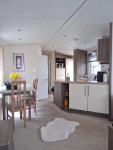 a kitchen and dining room with a table and chairs at Ascot at Lochlands in Forfar