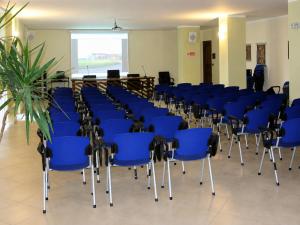 a conference room with blue chairs and a podium at Alisea Eco Residence in Pocapaglia +48 photos