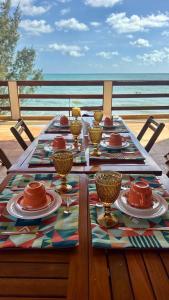 a table with plates of food on top of a deck at Pousada Mahalo Preá Beach in Prea