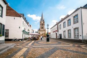 a city street with a clock tower in the distance at Het Molenaarshuis in Vijverbroek
